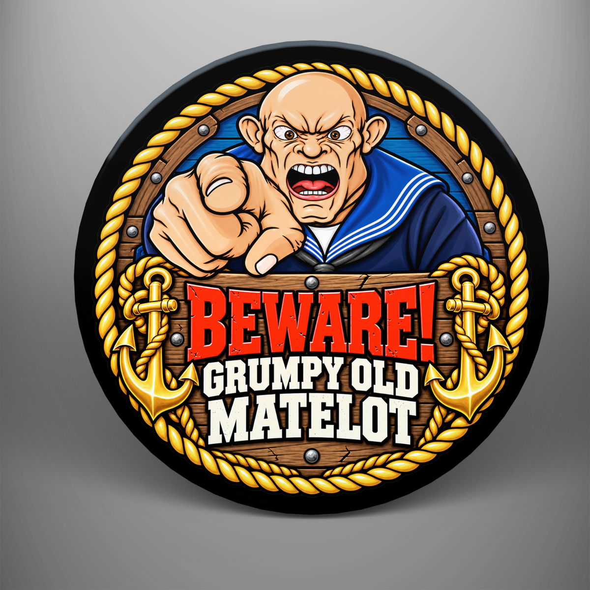 Round coaster featuring a pointing cartoon sailor with Beware! Grumpy Old Matelot wording, gold rope border and anchors